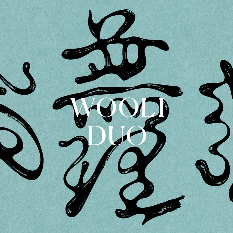 An album cover with a pale sky-blue background and glossy black calligraphic symbols drifting across the frame.