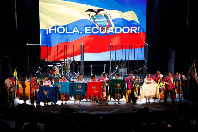 La Mar de Músicas 2026 announcement. People on stage with Ecuadoran flags.
