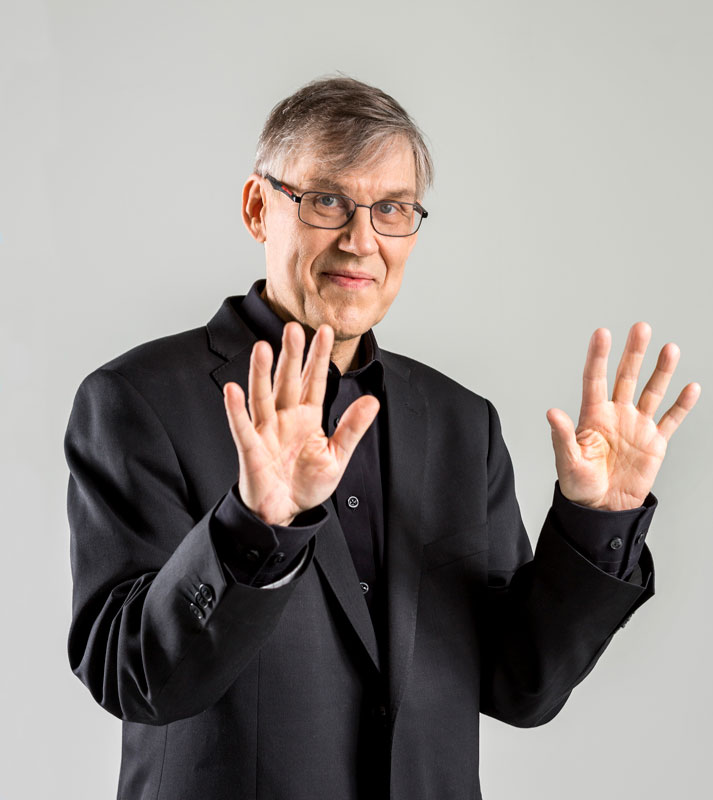 Timo Alakotila - Photos by Marko Mäkinen & Kimmo Tähtinen. Timo holding his hands up.