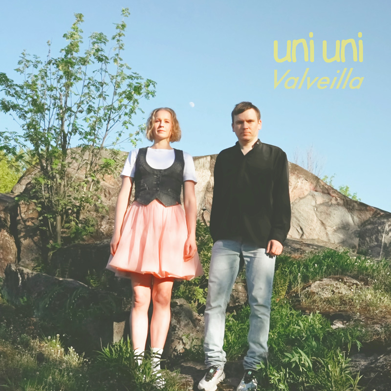 uniuni - Valveilla - photo by Mikko H Haapoja cover arwork. The two artistsstanding in front of a house. She is wearing a traditionsl dress.